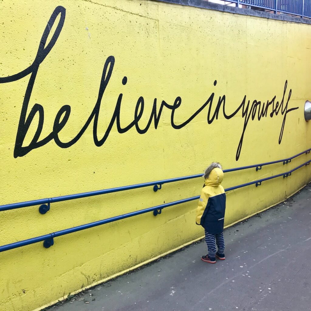 toddler looking at believe in yourself graffiti to help with positive mindset