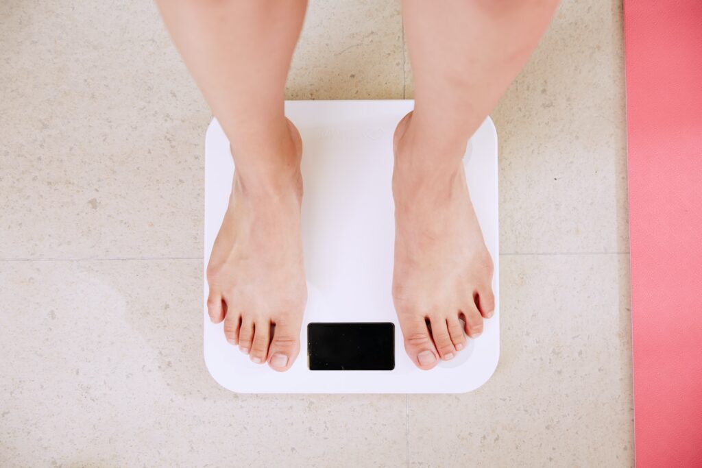 person standing on white digital bathroom scale losing weight
